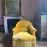 Fauteuil crapaud ancien en velours jaune d'or : élégance et confort vintage