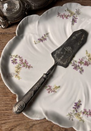 Plat ancien en porcelaine à motifs de fleurs époque 1900 avec sa pelle à tarte, un charme fou  Prix de vente de 52 euros  Livraison partout en France au choix 